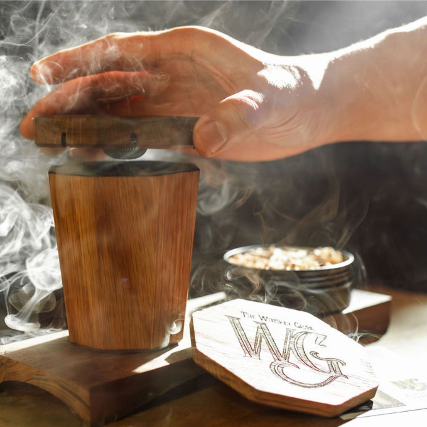 Hand using the Holy Smokes Smoker with The Whiskey Grail