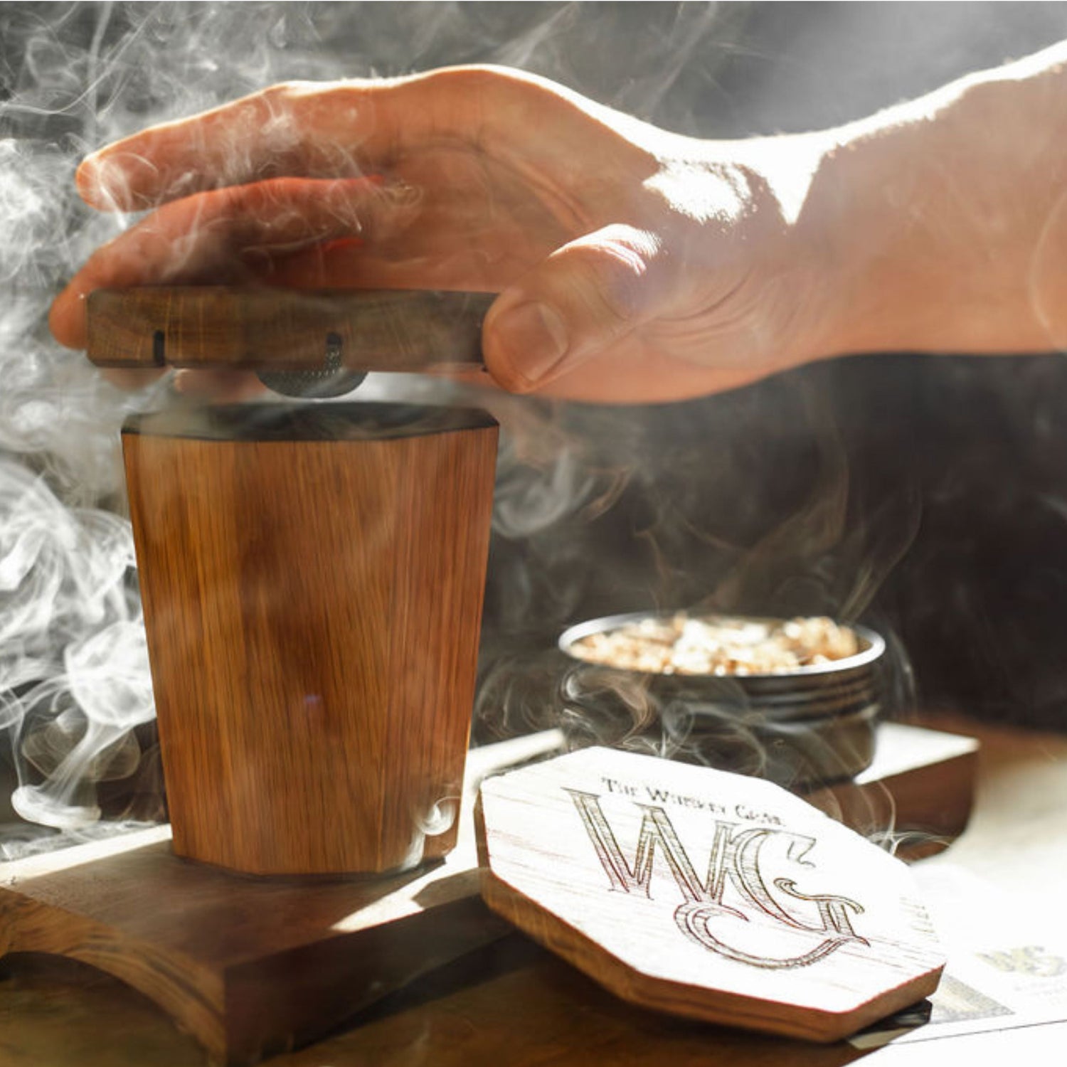 Hand using the Holy Smokes Smoker with The Whiskey Grail